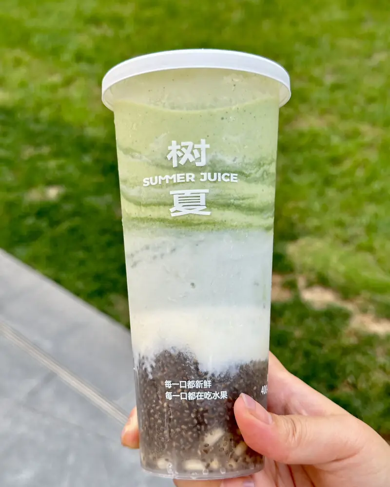 Kale smoothie held over grass